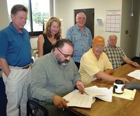 Signing Agreement. Photo by Kootenai Valley Record.